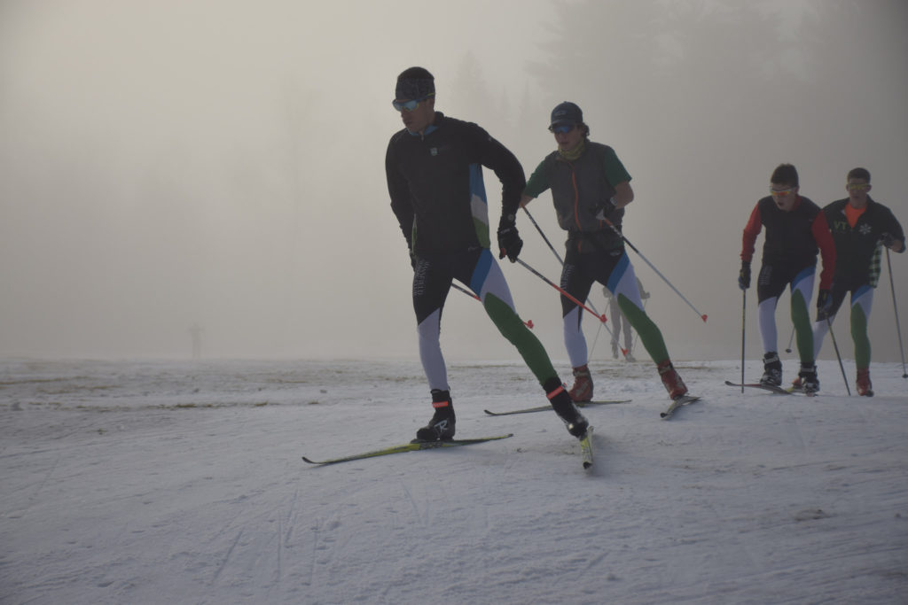 Coach Adam leading Kai, Aidan and Will through the fog